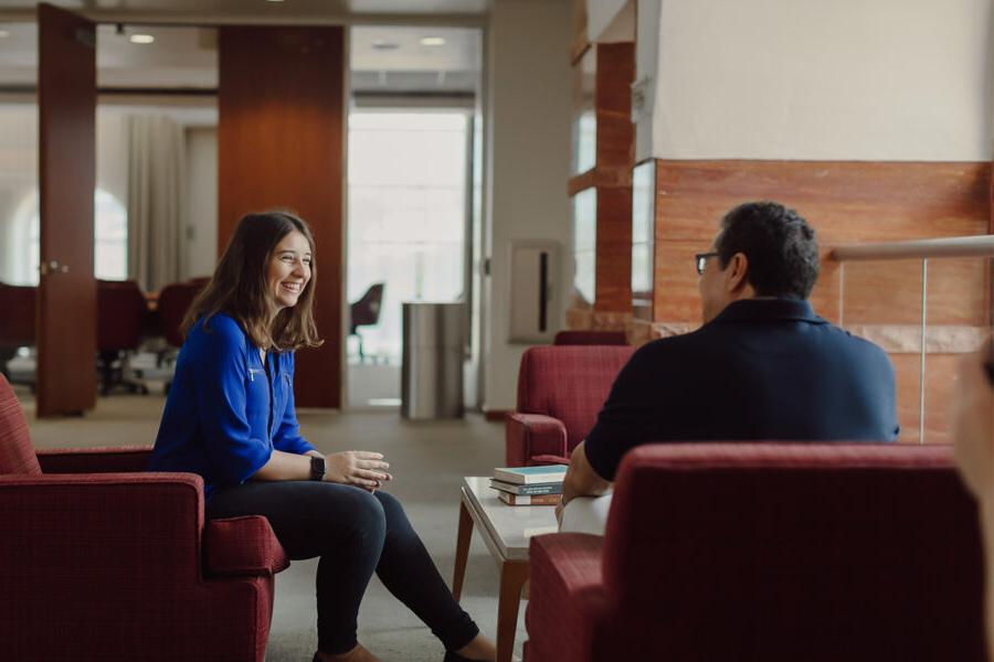 a student sitting in the library meeting with an admissions counselor